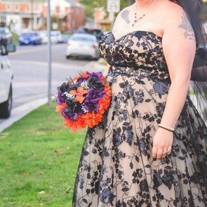 A Casablanca black lace over nude wedding gown. Size is between 18-22.